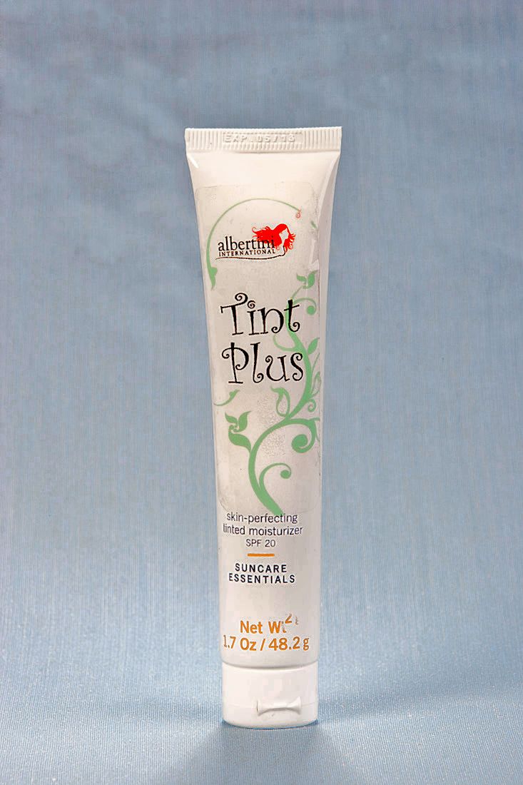 A tube of lotion with white and green writing.