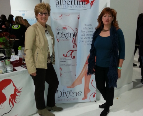 Two women standing in front of a banner.