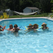 A group of people in the pool with hats on.